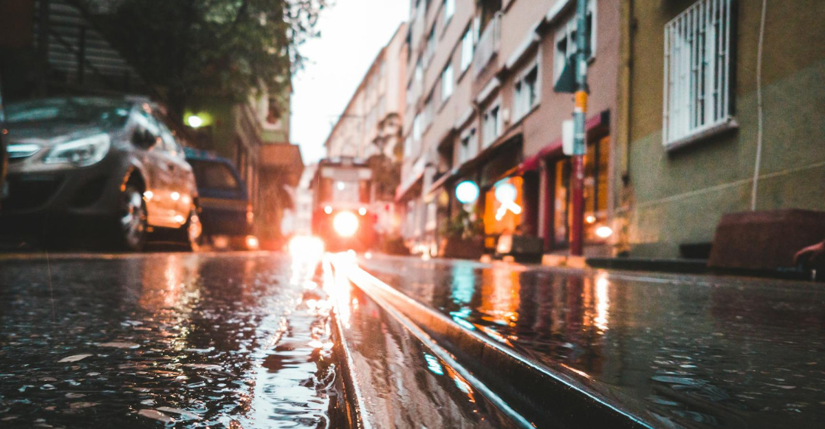 Moody street scene in Istanbul with a tram reflecting in rain-soaked pavement