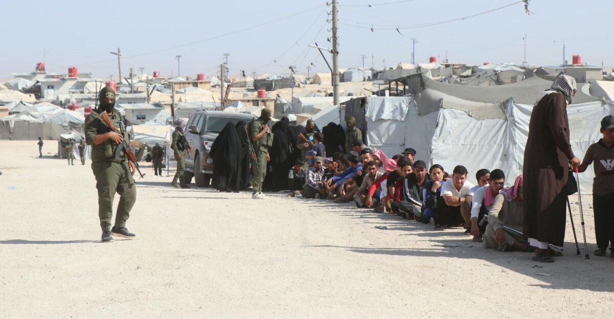 Refugees in al-Hol camp Syria guarded by soldiers highlighting humanitarian crisis