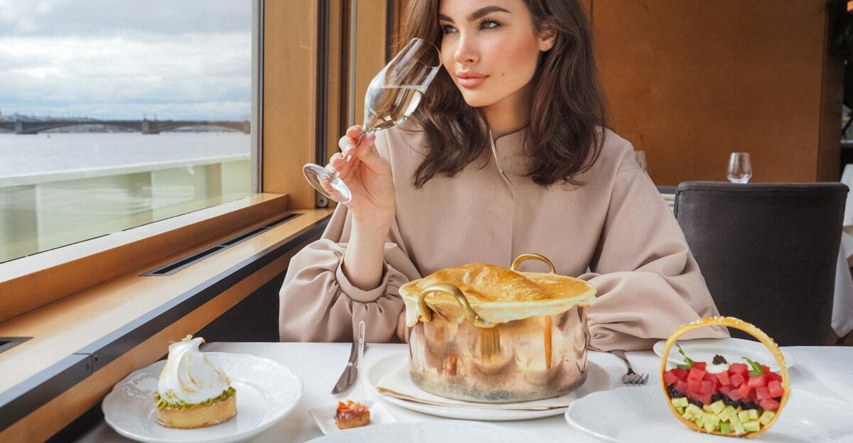 Elegant woman savoring wine during a gourmet meal on a luxury cruise with sea views