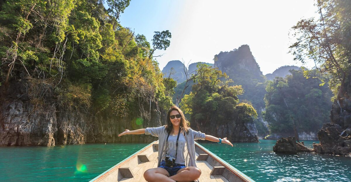 Asian woman relishing a serene boat journey through the lush karst landscape of Thailand s Khlong Sok
