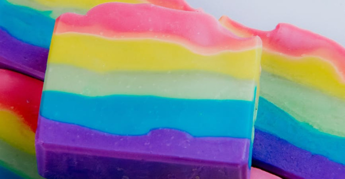 Colorful handmade rainbow soap bars stacked on a white background perfect for body care product promotion