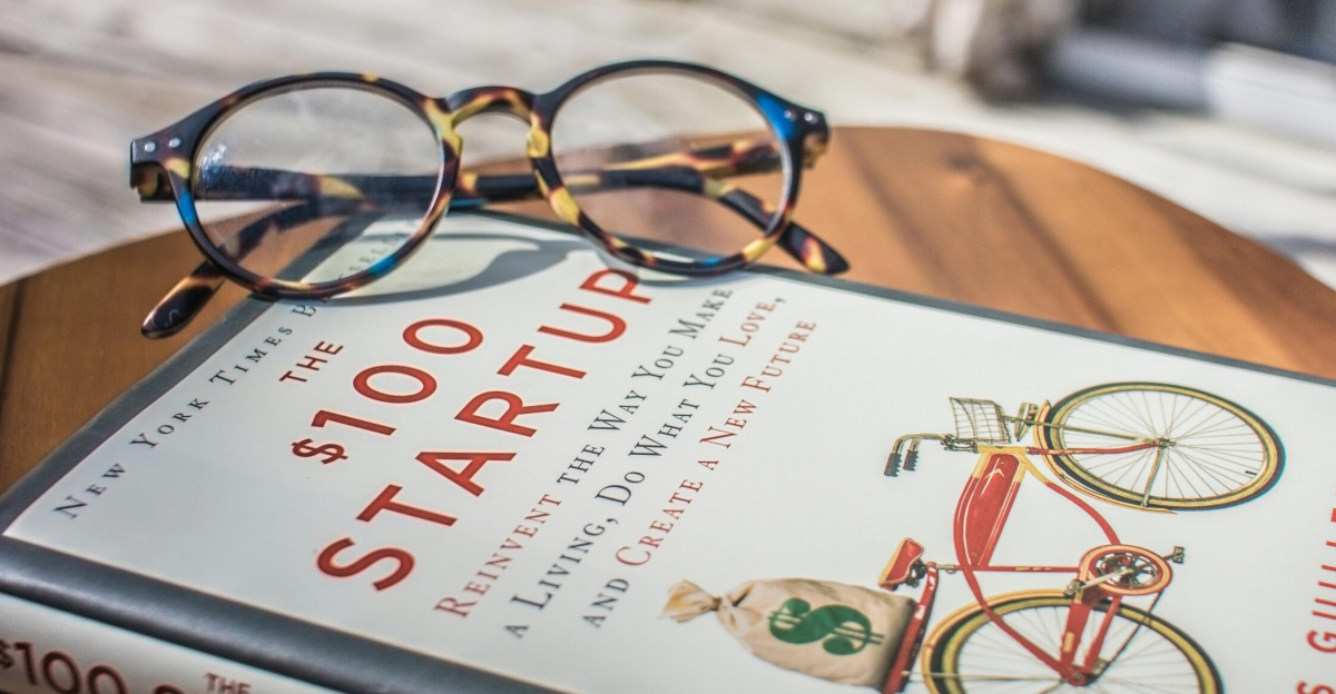Close-up of a book and eyeglasses on a table, perfect for study or leisure reading.
