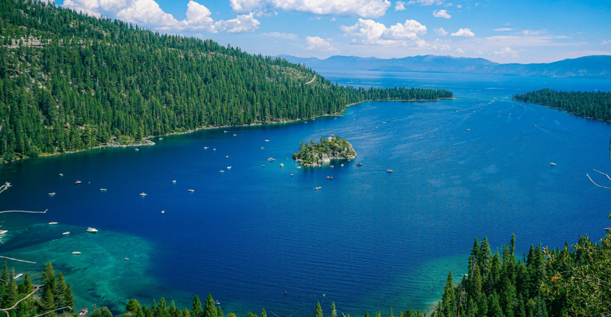 A breathtaking aerial view of Lake Tahoe's emerald bay and Fannette Island under a clear blue sky.