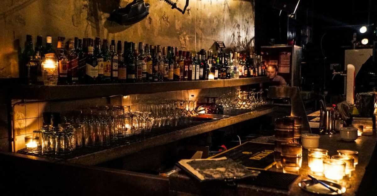 A cozy bar setup with whiskey bottles and warm candlelight creating a relaxed mood