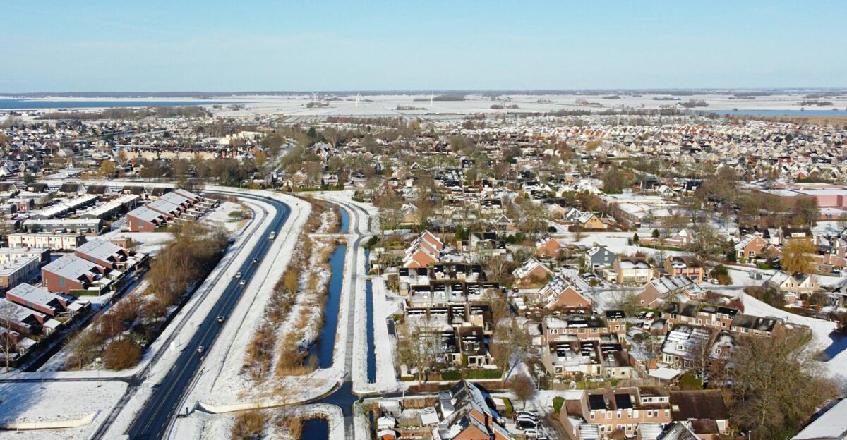 Aerial view of a suburban residential district covered in snow showing roads houses and urban planning