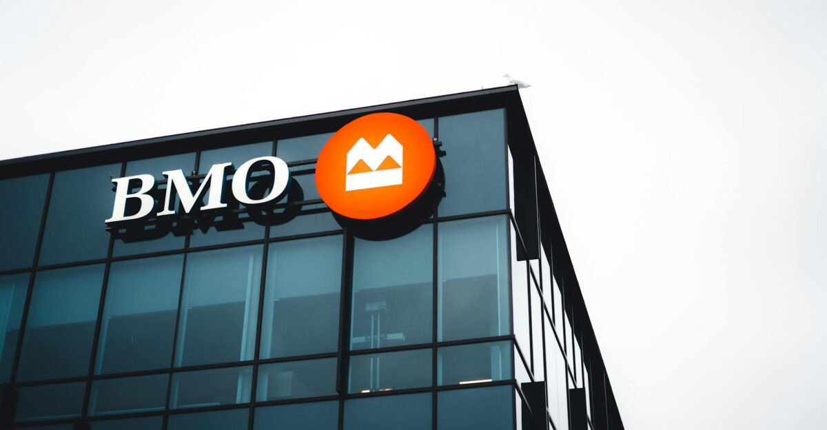 Close-up of a modern building corner featuring a BMO logo on its glass facade
