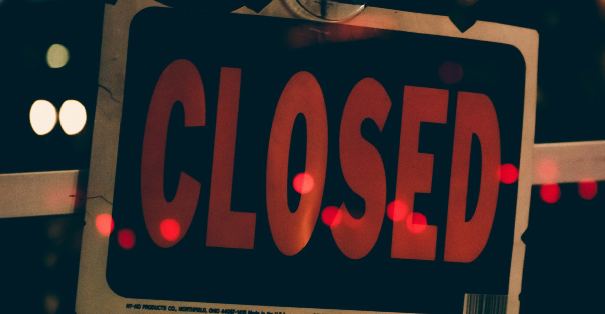 Moody image of a closed sign with bokeh lights, conveying nighttime closure.