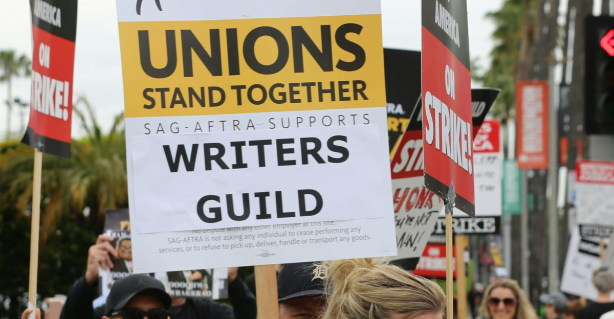Group of protesters with placards supporting Writers Guild on a street demonstration.