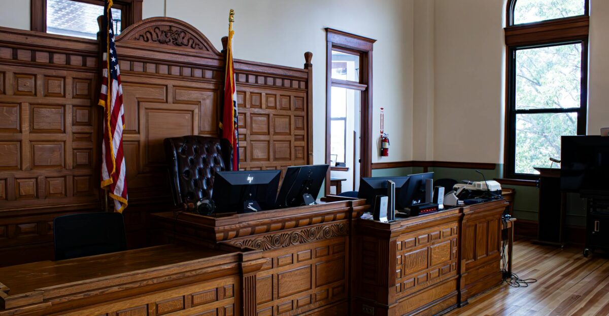 Interior view of an American courthouse in Kirksville Missouri featuring a judge s desk and flags