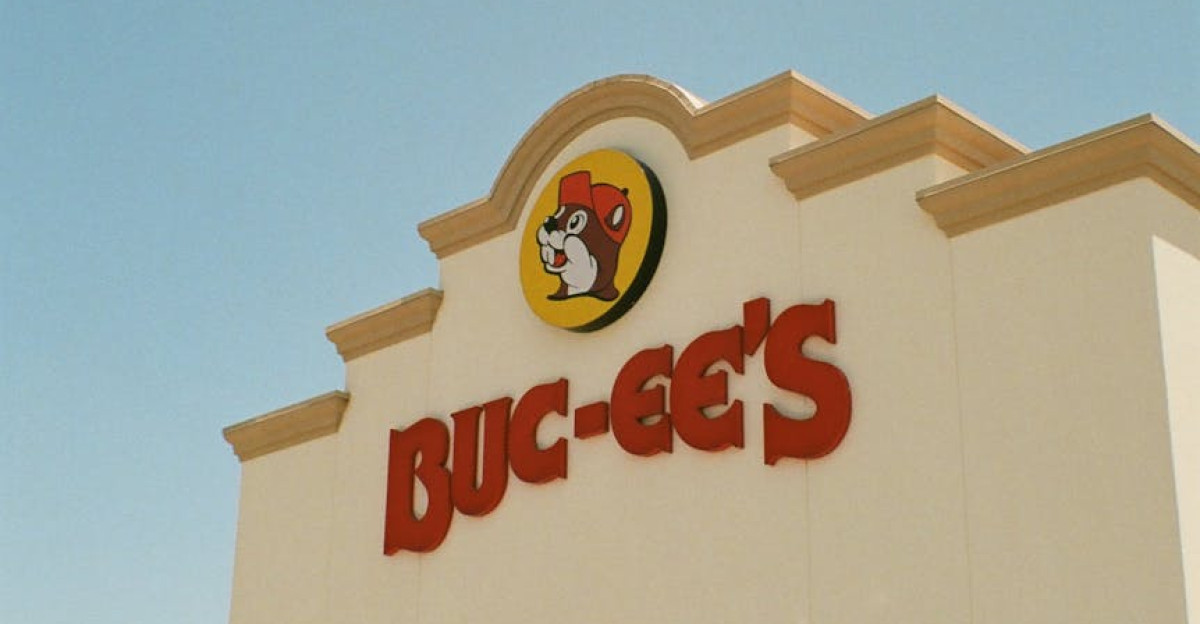 Buc-ee s storefront showcasing its iconic branding under a clear blue sky with parked vehicles