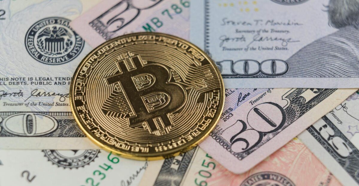 Close-up of a Bitcoin coin on US dollar banknotes symbolizing cryptocurrency and traditional finance