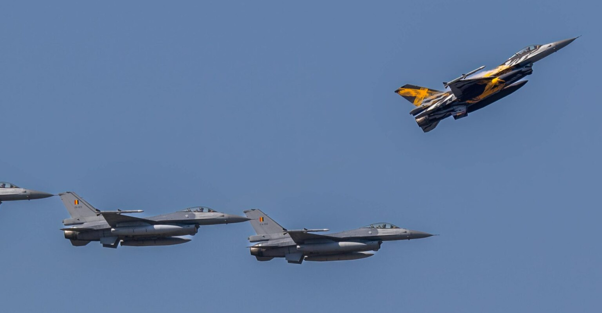 Aerial view of F-16 fighter jets flying in formation against a clear blue sky.