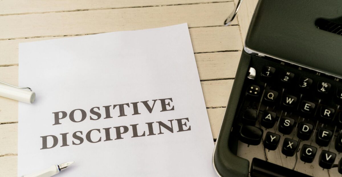 Vintage typewriter next to a paper with Positive Discipline text symbolizing communication and education