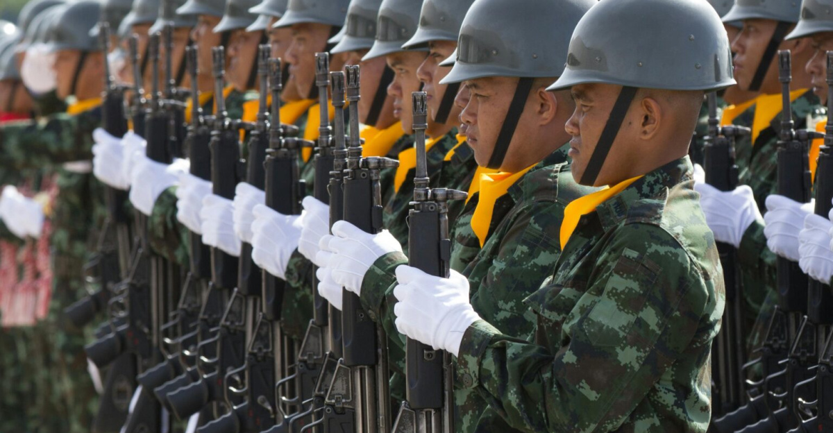 Soldiers in uniform march in a disciplined formation during a military parade outdoors.