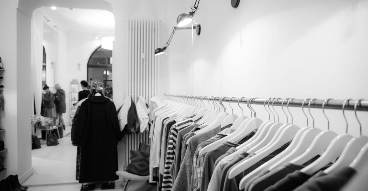 Stylish black and white interior of a boutique with clothes on racks showcasing modern fashion