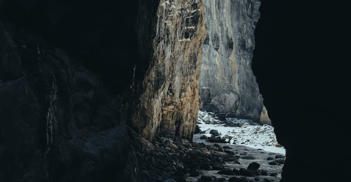 Explore the dark rocky passage of Grindelwald s natural cave showcasing dramatic lighting and textures