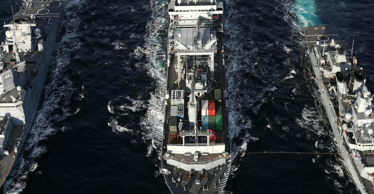 Naval ships sailing in formation on open sea, aerial view highlights naval coordination and strategy.