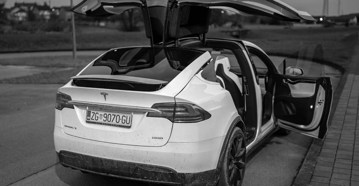 Black and white photo of Tesla Model X with open falcon wing doors in Gare nica Croatia