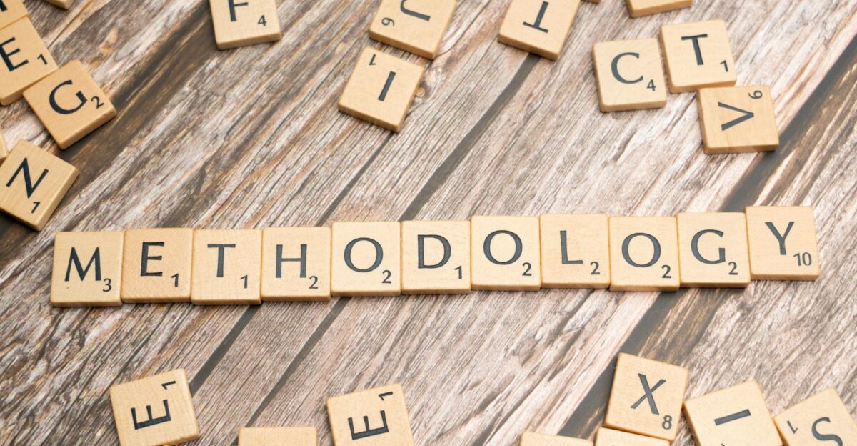 Wooden letter tiles spelling methodology on a textured wooden surface emphasizing research