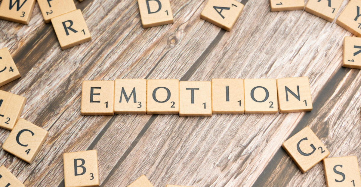 Scrabble tiles forming the word emotion on a wooden background.