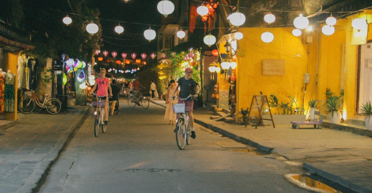 Cyclists enjoying a night ride through the lantern-lit streets of Hoi An Vietnam