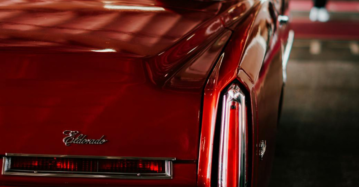 Rear view of a classic red Cadillac Eldorado on display at an indoor car show