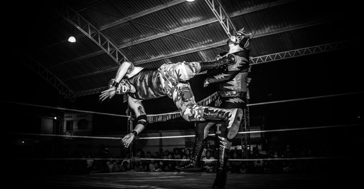 Intense Lucha Libre wrestling match showcasing strength and agility under dramatic lighting