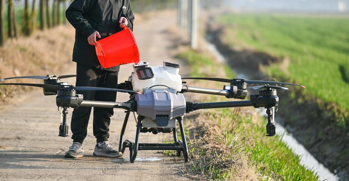 Person using a drone for agricultural purposes on a countryside pathway in Hefei China