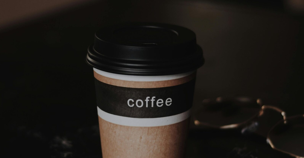 A close-up shot of a coffee cup set against a dimly lit background, creating a warm and inviting atmosphere.