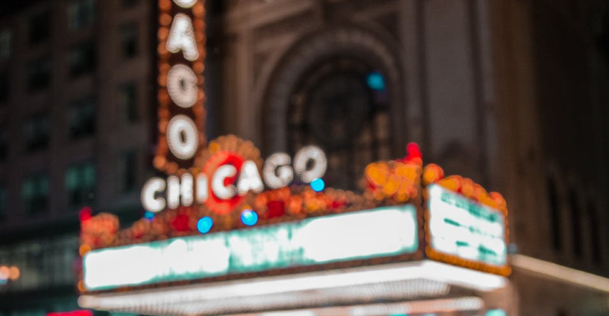 Iconic Chicago Theater illuminated with neon lights reflecting on wet pavement at night