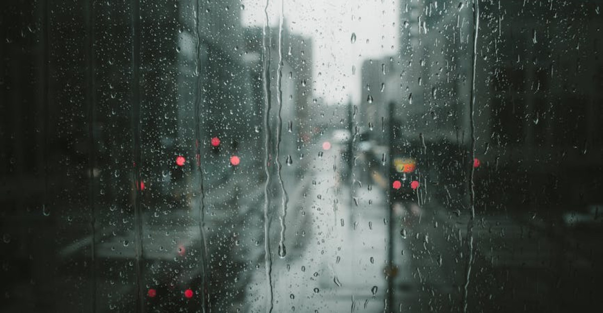 Moody view of a rainy day in Minneapolis capturing the urban scene through a glass window with raindrops