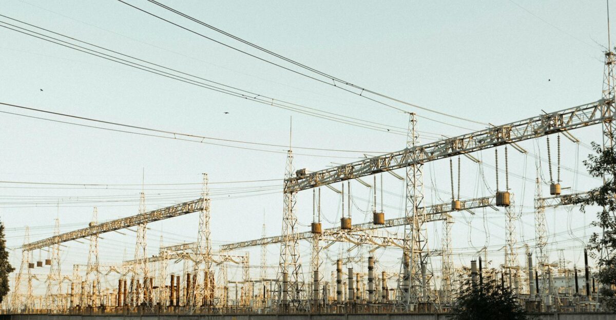 A wide view of an industrial electrical substation with power lines and towers outdoors