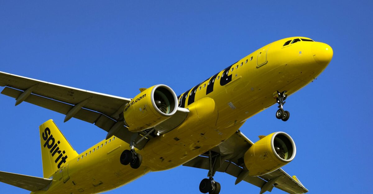 A vivid yellow commercial airplane in flight against a clear blue sky showcasing dynamic travel and aviation