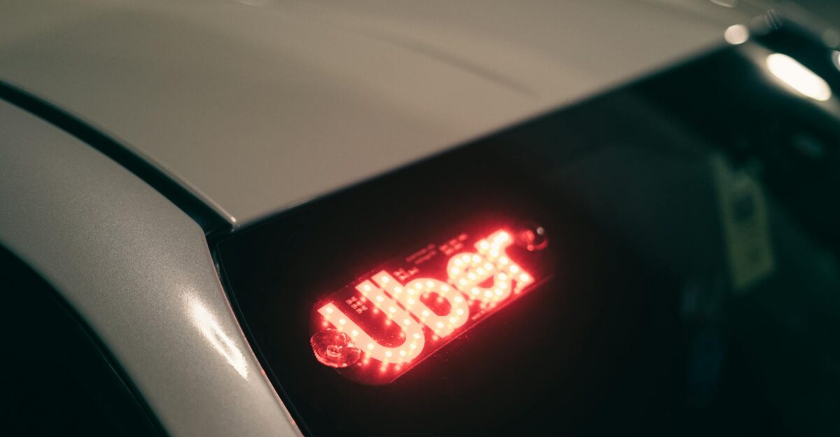 Close-up of a ride-sharing car with a bright red illuminated sign for night-time travel