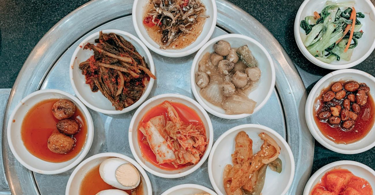 A top view of various traditional Korean side dishes served on a restaurant table showcasing a flavorful meal