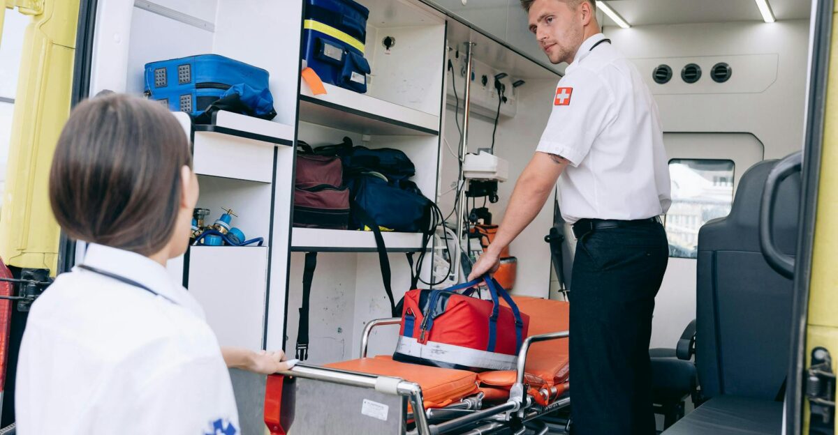 Two paramedics organizing medical supplies in an ambulance for emergency readiness