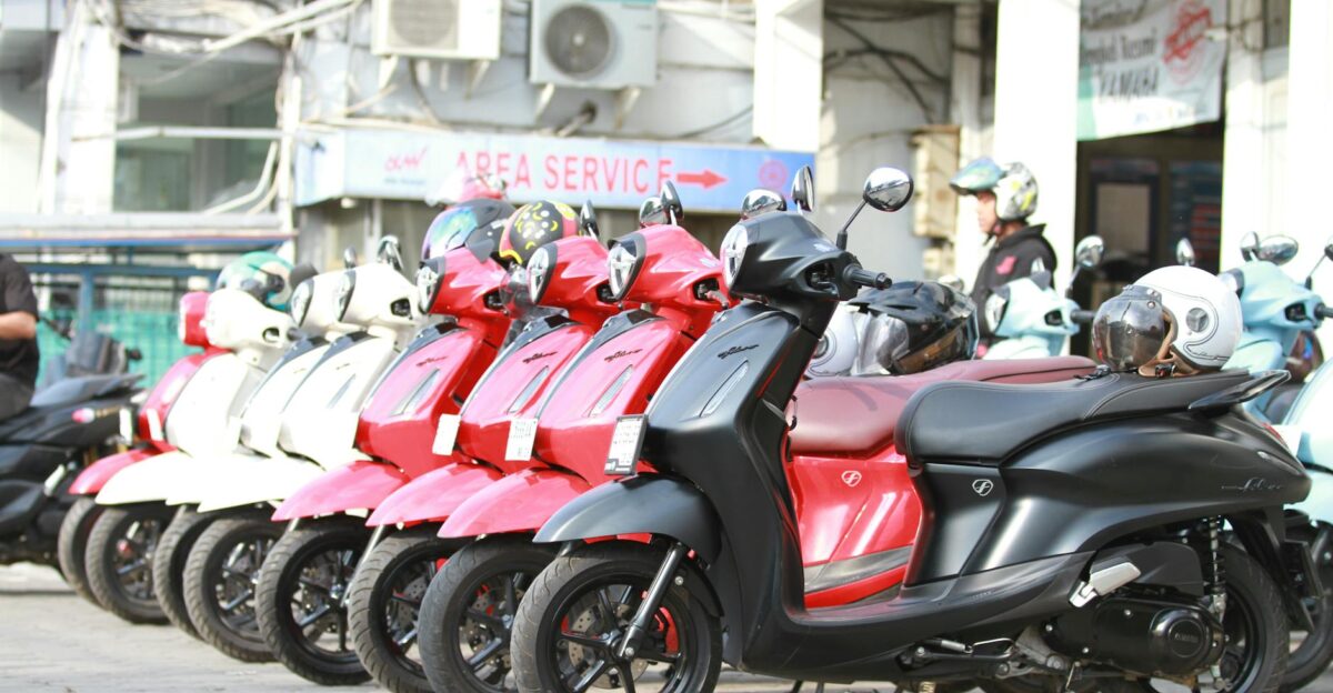 A lineup of colorful motor scooters parked outdoors at a service area showcasing modern design