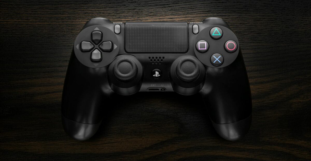 High-resolution image of a Sony DualShock 4 game controller against a dark wooden background