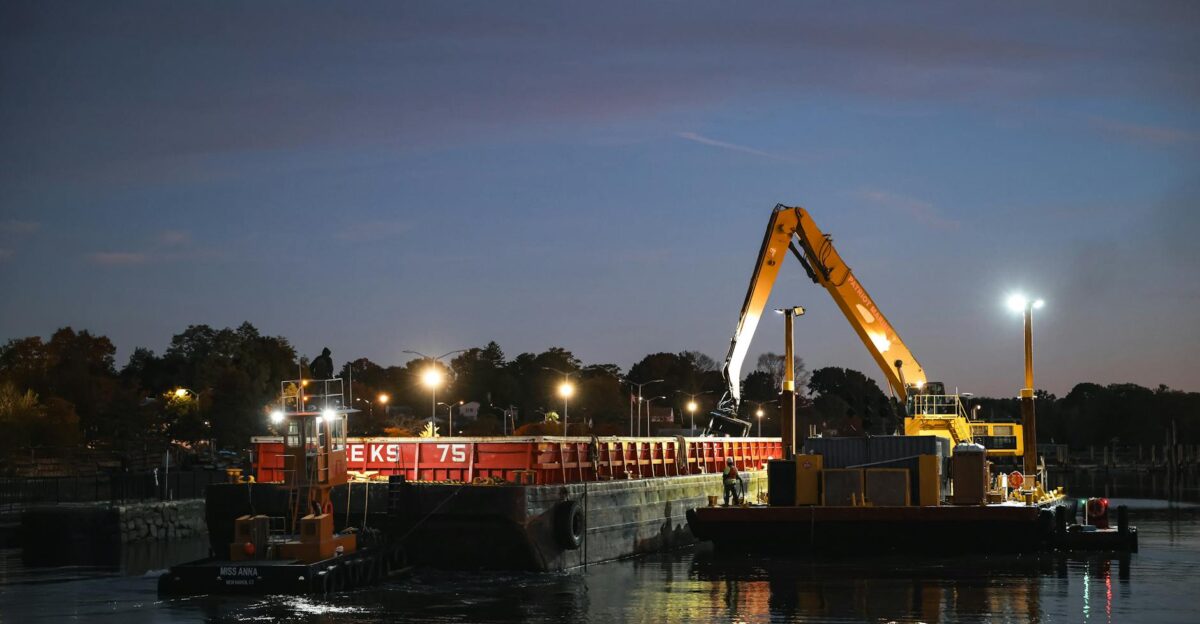 Heavy equipment dredging at dusk in Stamford Marina Connecticut creating a striking industrial scene
