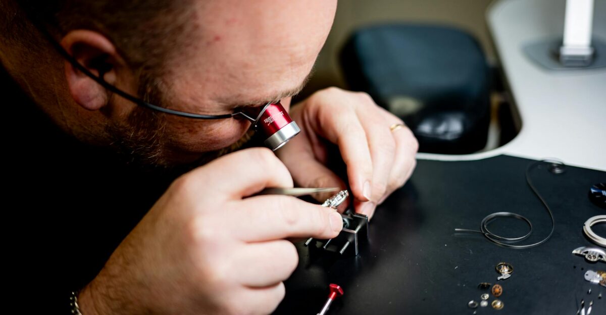 Watchmaker meticulously fine-tuning a watch mechanism with precision tools