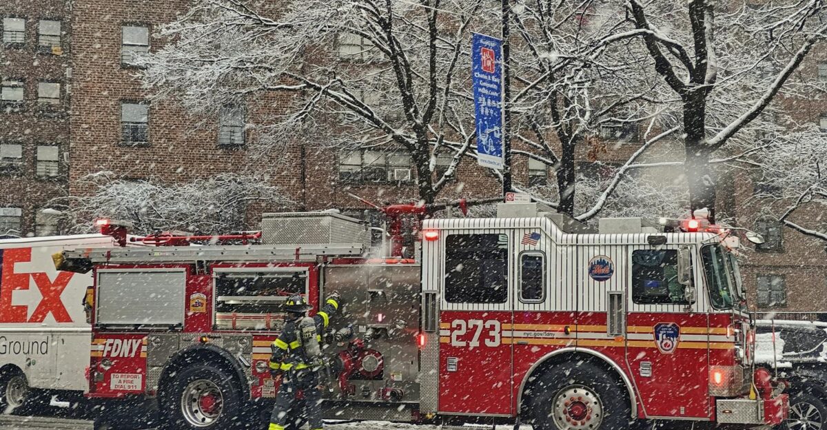 Firetruck and firefighters in action on a snowy city street