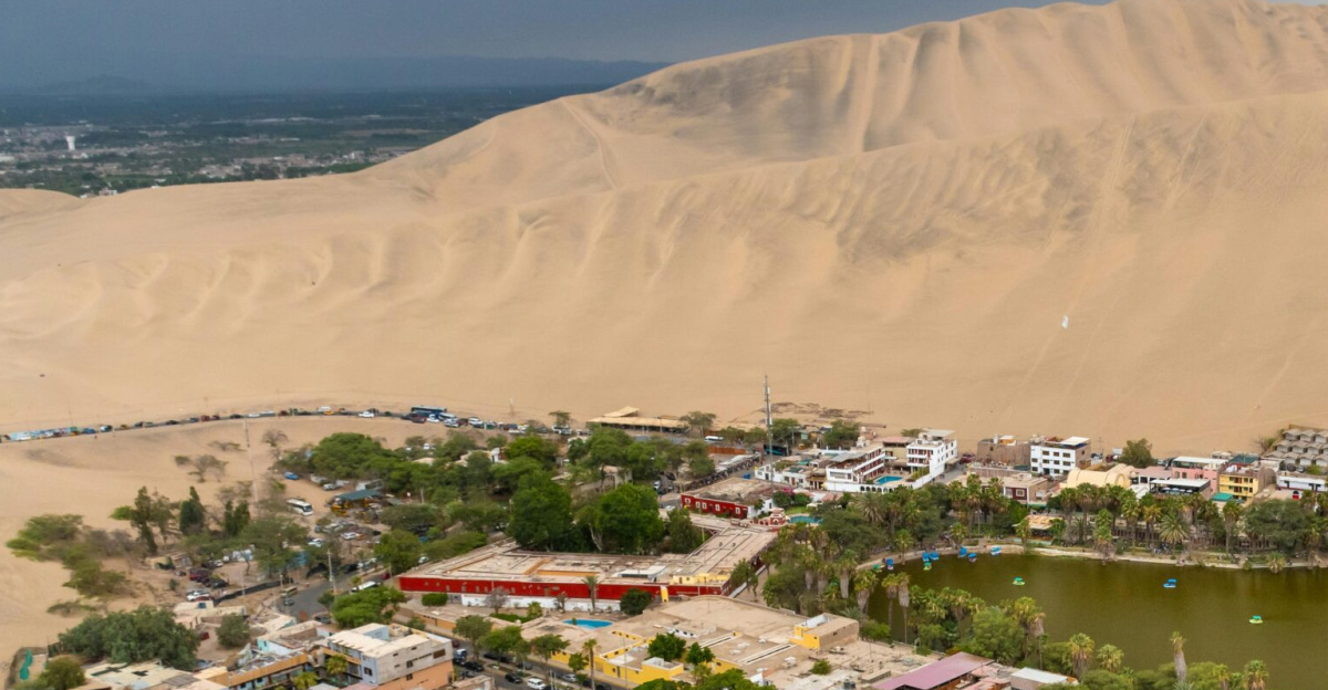 Stunning aerial view of Huacachina Oasis surrounded by sand dunes in Ica, Peru.