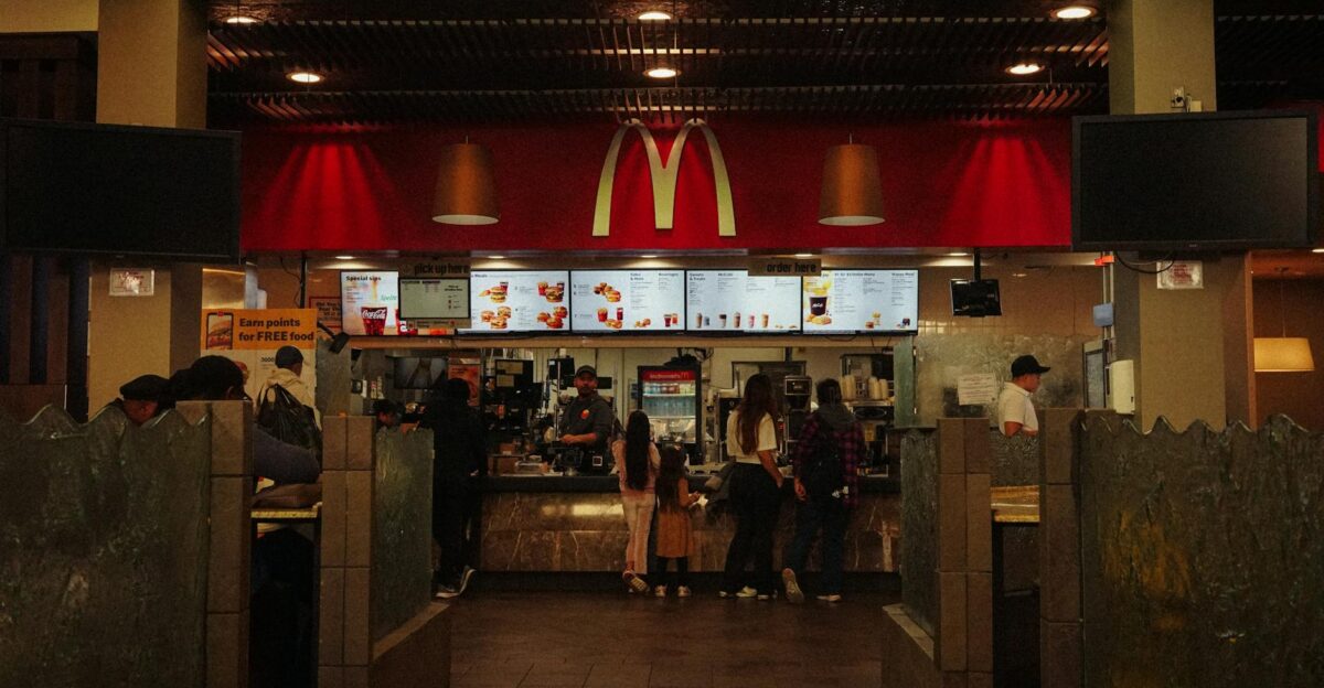 A bustling scene at a McDonald s restaurant counter with customers and staff in an indoor setting
