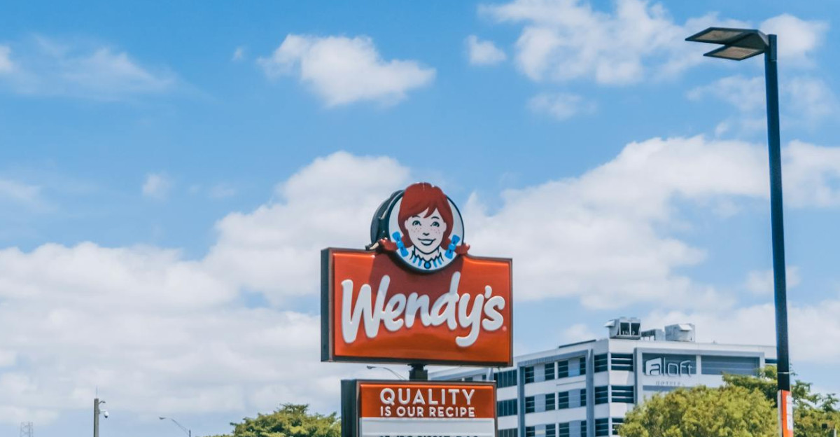 Wendy s parking area crowded with cars under a clear blue sky in Orlando