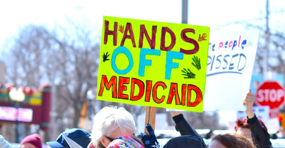A diverse group protests to protect Medicaid holding signs advocating healthcare rights