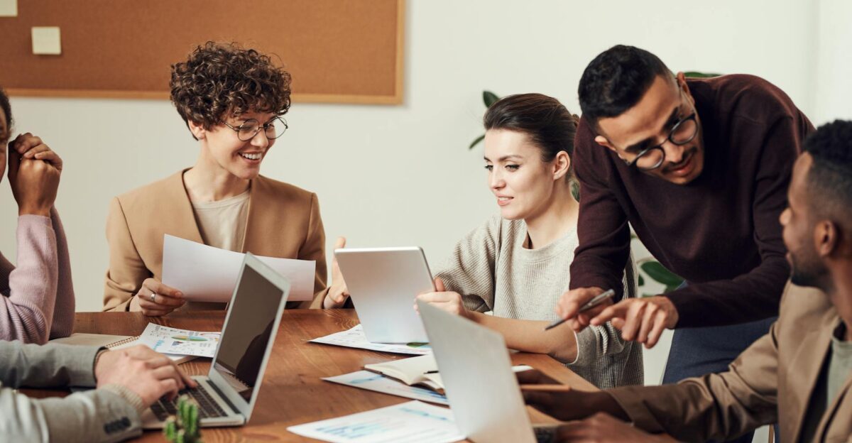 A diverse group of professionals engaged in a collaborative office meeting sharing ideas and discussing projects