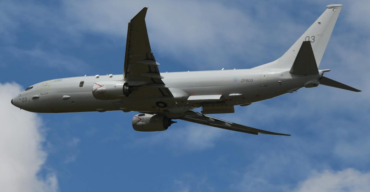 Military aircraft flying over England showcasing aviation technology against blue sky
