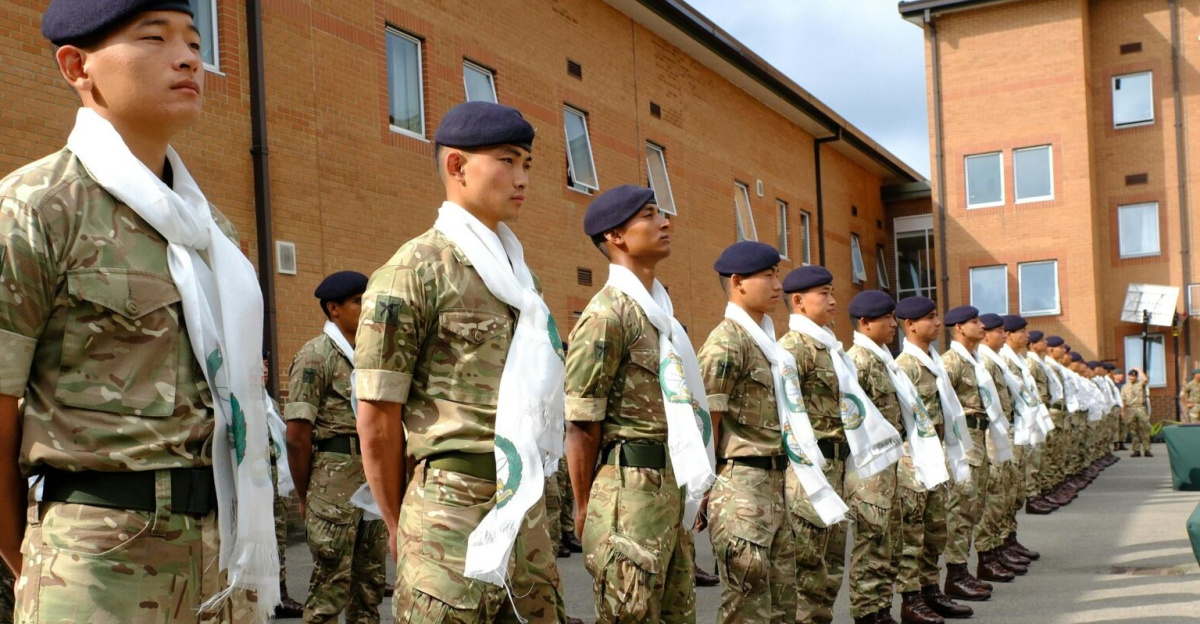 Gurkha soldiers in military uniforms stand in formation for an outdoor ceremony.