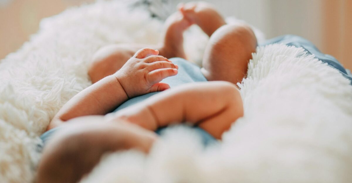 A serene close-up of a sleeping newborn lying on a fluffy blanket indoors