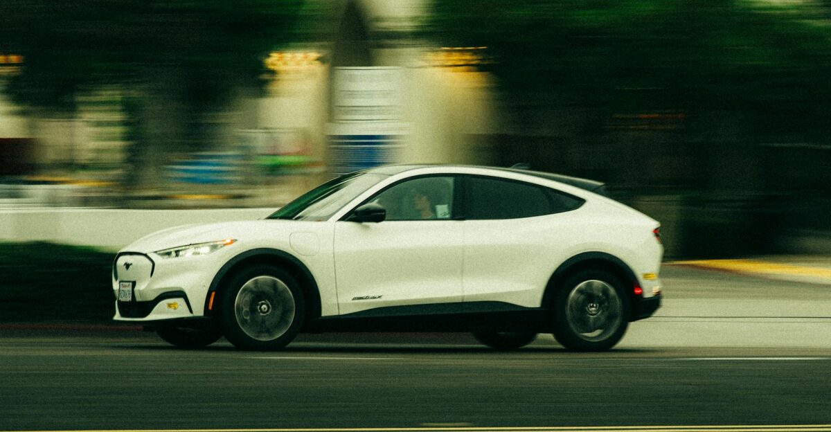 A white electric vehicle speeds through the streets of San Diego California showcasing modern automobile design